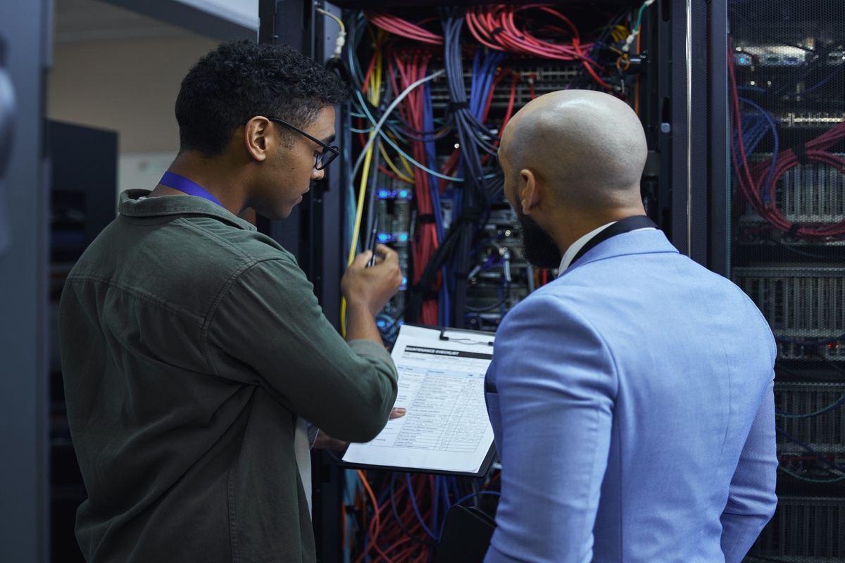 Network technicians working in server room.