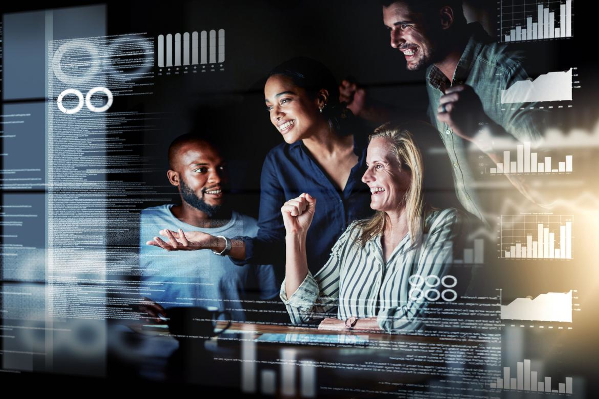 Four colleagues celebrating results on a screen covered in code.