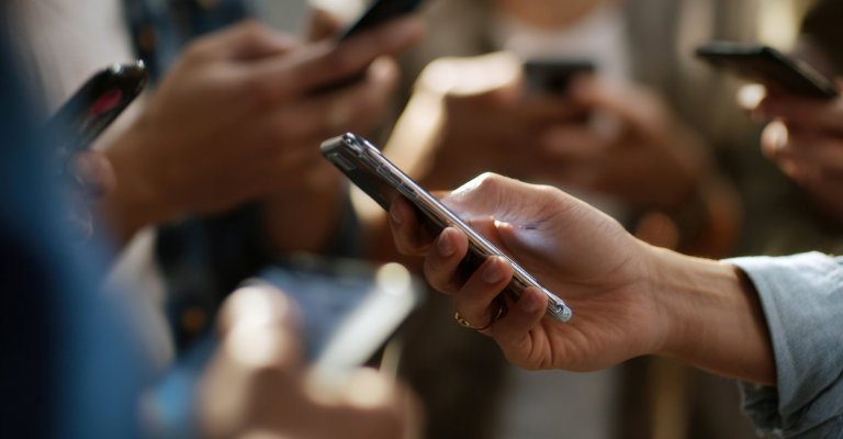 Close up of person's hand holding and interacting with a smartphone
