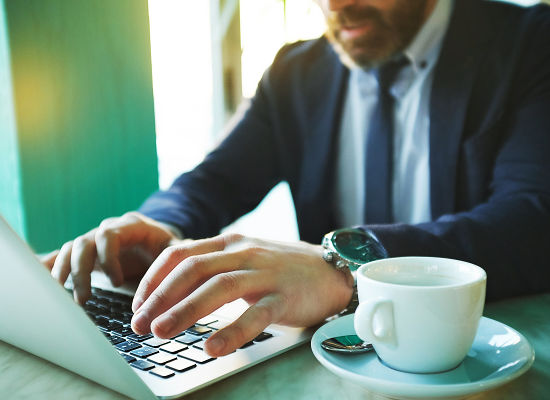 Man working on laptop and drinking coffee