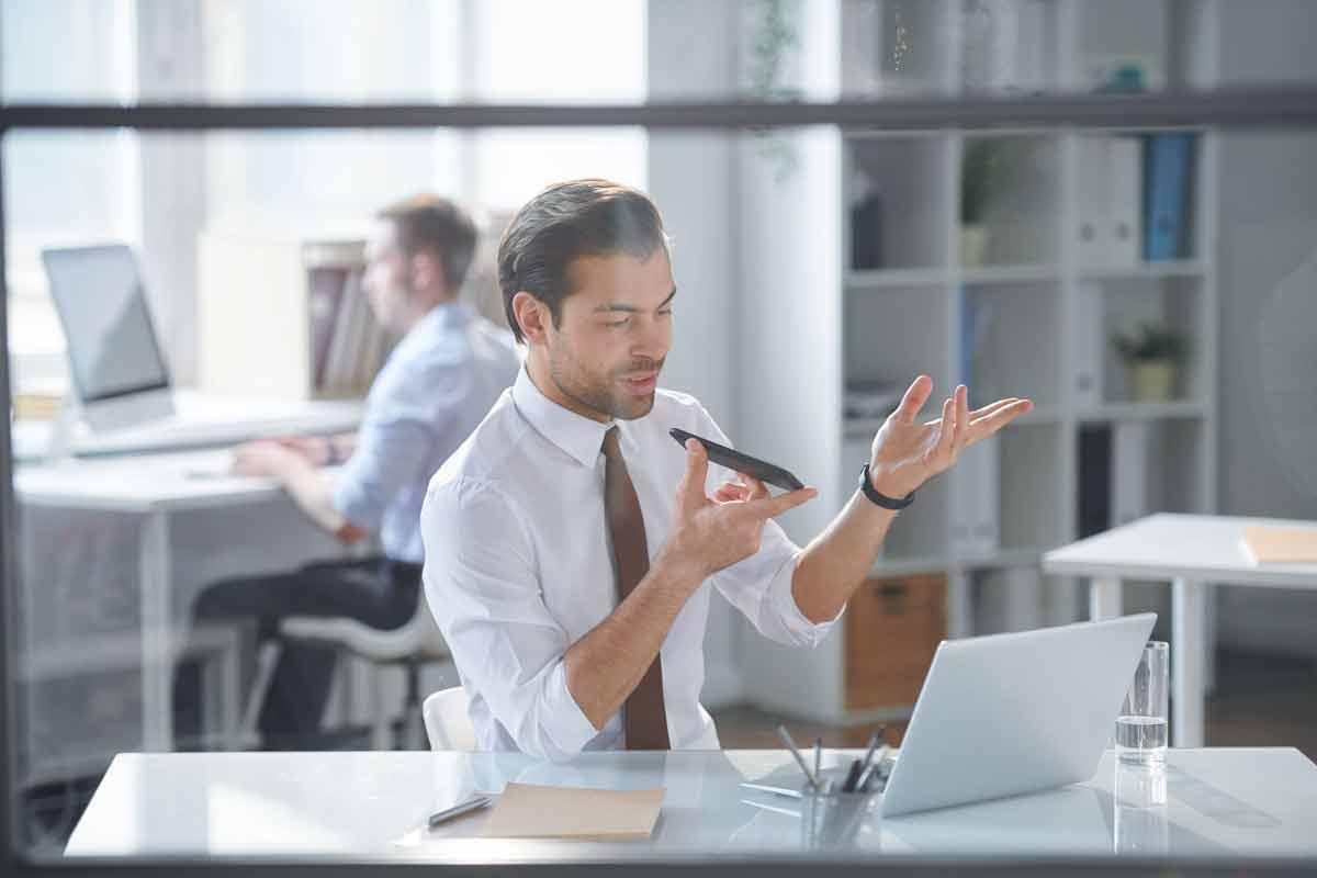 Man working on laptop and talking on mobile phone