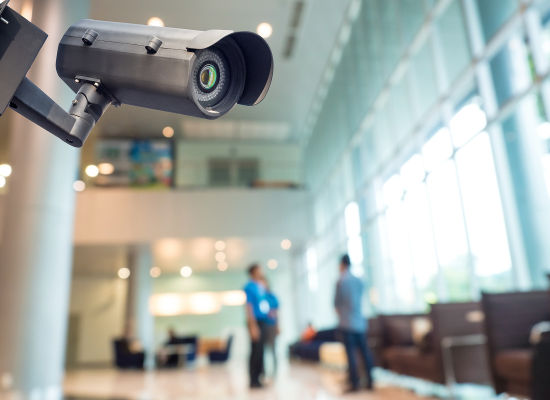 Video surveillance camera in modern office, against blurred background